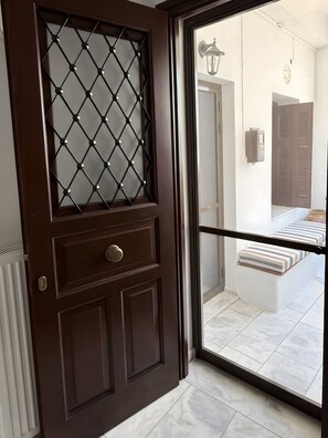 A dark wooden door with a diamond-patterned glass panel, a metal handle, and a keyhole.