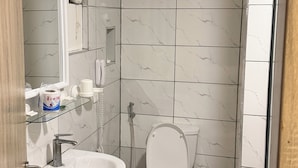 A bathroom with a white sink, mirror, toilet, and shower. - No 1 by Swiss park (Lagos)