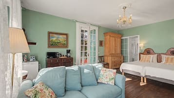 Una habitación con sofá, cama, armario y un cuadro en la pared.
