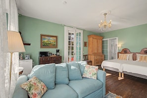 Une pièce comprenant un canapé, un lit, une armoire et un tableau accroché au mur.