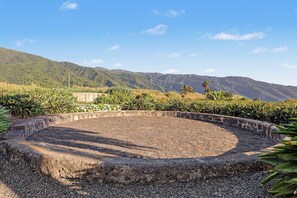 A circular stone structure surrounded by gravel, with a mountainous backdrop and vegetation. - Suite Balcony Room with Mountain Views, Shared Pool & Wi-Fi (Breña Alta)