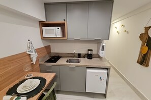 Eine kleine Küche mit Mikrowelle, Kaffeemaschine und Geschirrspüler.