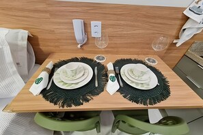 Ein ordentlich gedeckter Esstisch mit Tellern, Besteck und Gläsern.
