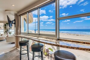 Un interior moderno con amplios ventanales con vistas a una playa.