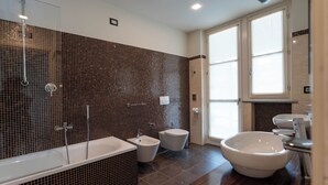 A modern bathroom with a large bathtub, two sinks, and a toilet. - LOSTU Monforte (Monforte d'Alba)