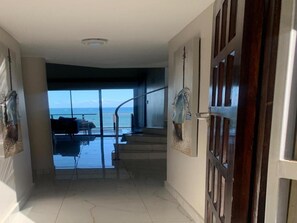 Un pasillo que lleva a un balcón con vista al mar.