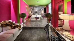 Un couloir d’hôtel avec un lit, un chat et une lampe.
