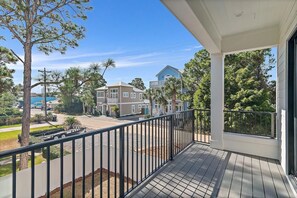 A balcony with a view of a residential area, including houses and a street. - 30A House Co: The Henderson House (SANTA RSA BCH)
