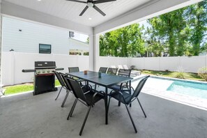 An outdoor patio with a pool, a grill, and a dining table with chairs. - 30A House Co: The Henderson House (SANTA RSA BCH)
