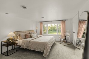 A bedroom with a bed, bedside table, lamp, chair, and a window with curtains. - Welcome to the magic of Langford Creek Farm (Chestertown)