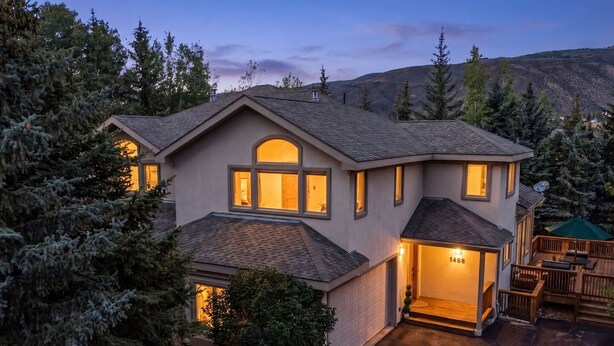 A two-story house with a garage, surrounded by trees and a hilly landscape. - EagleVail Mountain Retreat w/Large Deck & Fire Pit (Avon)