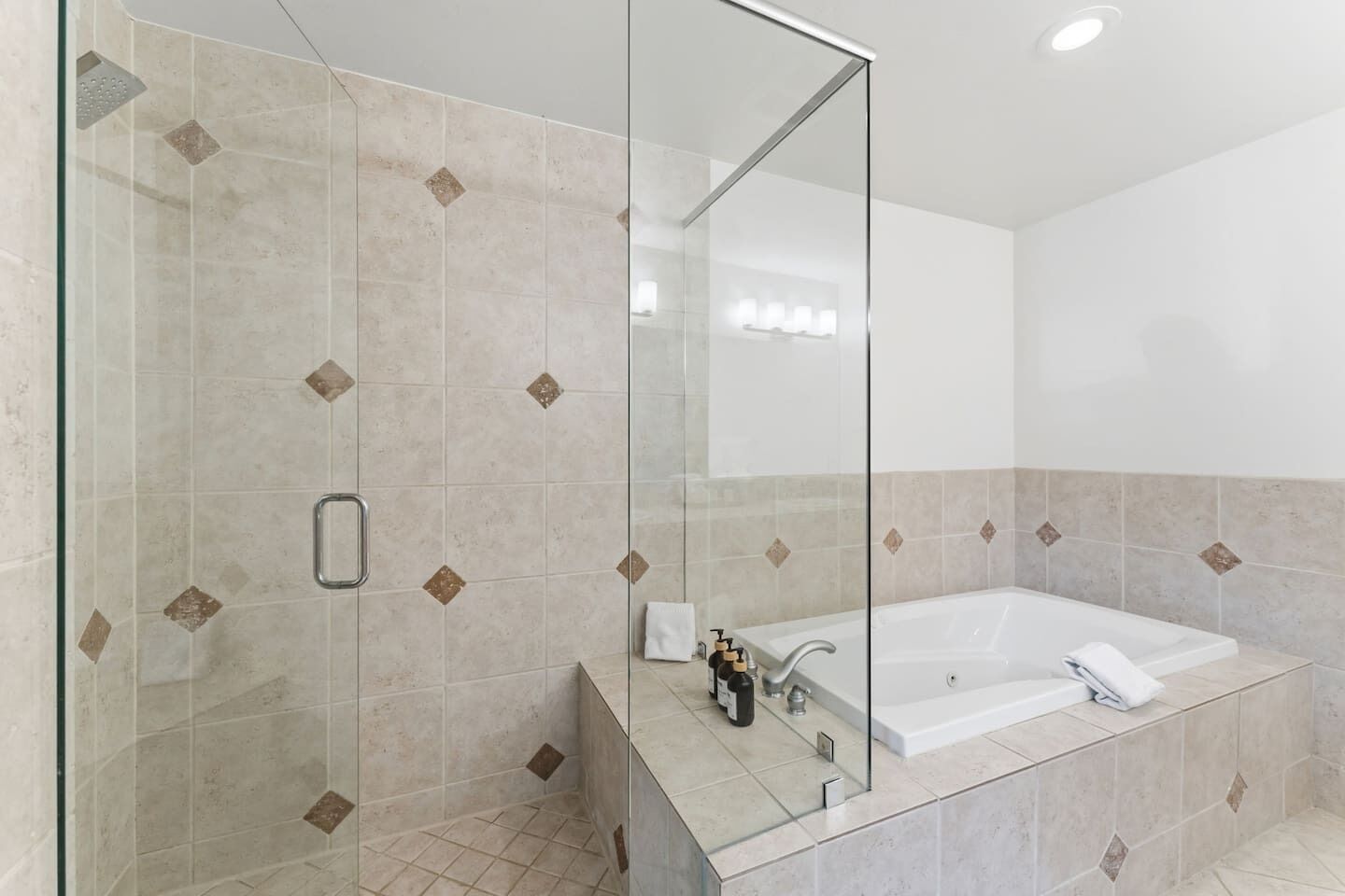 A modern bathroom with a glass shower enclosure, a large bathtub, and a mirror.
