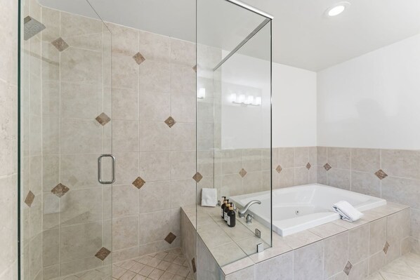 Ein modernes Badezimmer mit einer Glasdusche, einer großen Badewanne und einem Spiegel.