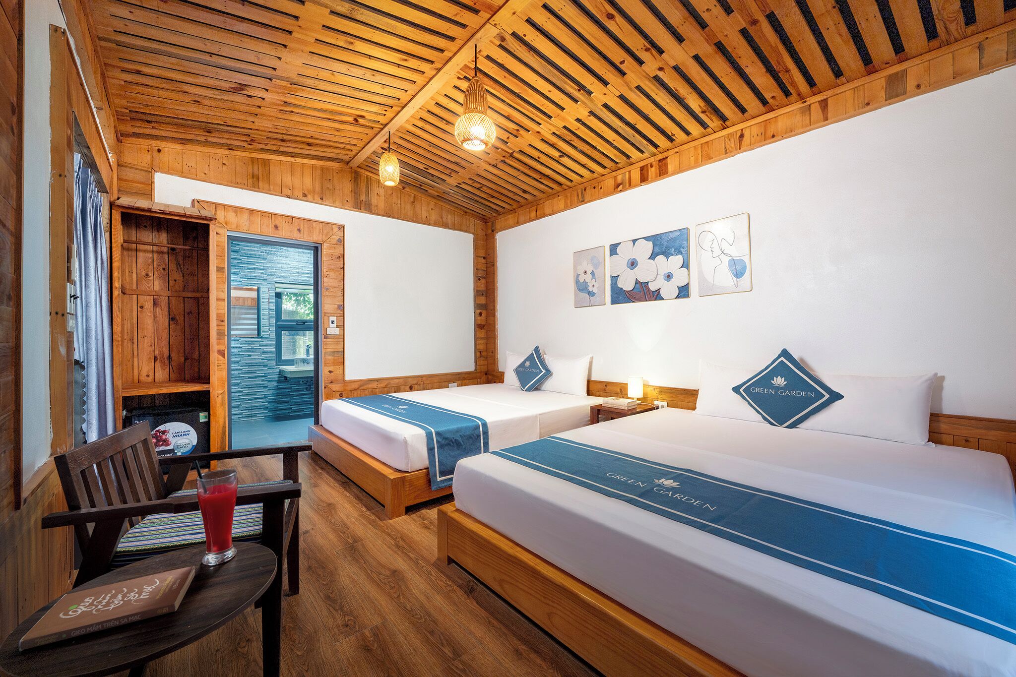 A wooden room with two beds, a desk, and a window.