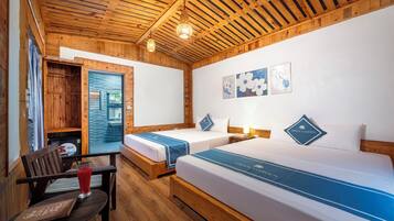 A wooden room with two beds, a desk, and a window.