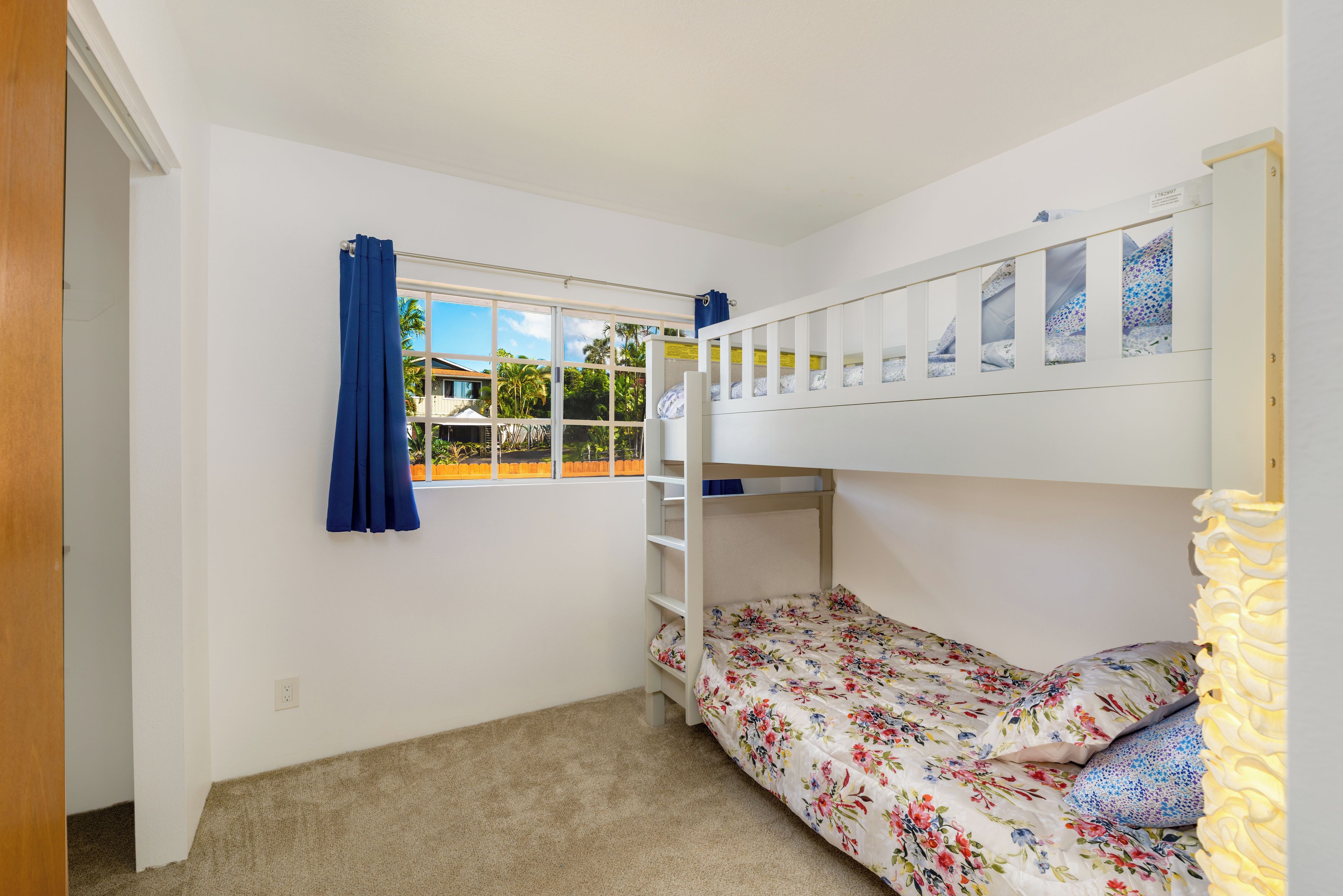 A bunk bed room with a window, a door, and a carpeted floor.