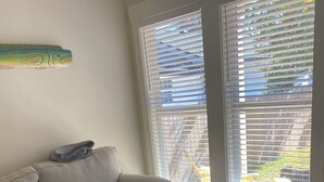 Uma sala de estar com um sofá, uma mesa de centro de madeira e um tapete listrado e colorido.