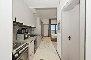 A modern kitchen with a built-in oven, microwave, and coffee maker. - Bloomfields Studio Mag Eye 910 - Meydan (Dubai)