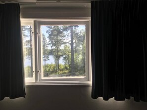 A window with a view of a lake and trees.