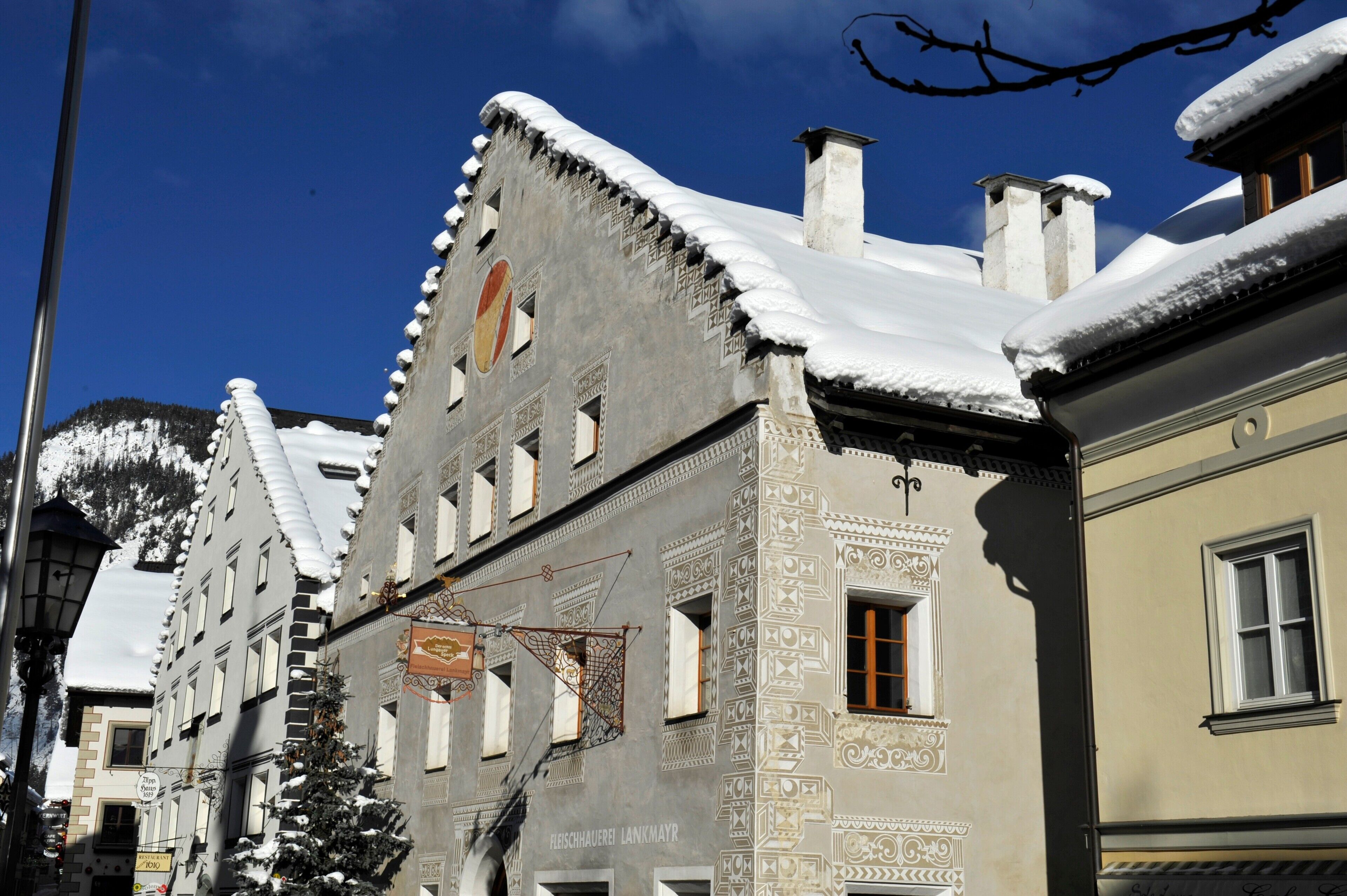 Un bâtiment dont les toits sont recouverts de neige et sur lequel on peut voir une enseigne indiquant la présence d’un restaurant.