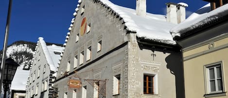 Un edificio con tejados cubiertos de nieve y un letrero que indica un restaurante.