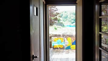 A narrow hallway leading to an outdoor area with a wooden deck and colorful painted blocks.