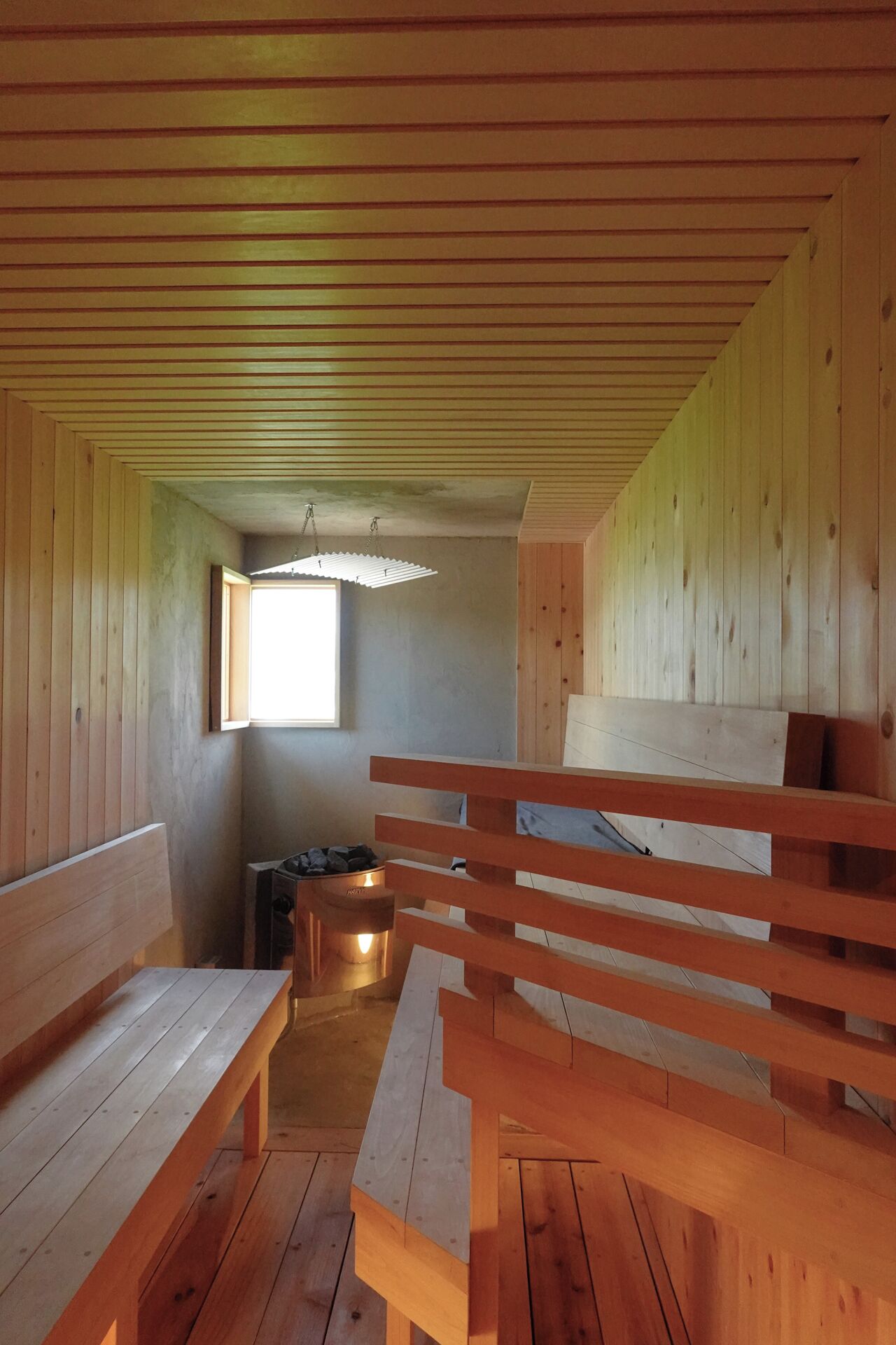 Een houten interieur met banken en een open haard.