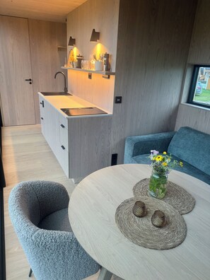 Una kitchenette compacta con pileta integrada e iluminación sobre la zona de trabajo.
