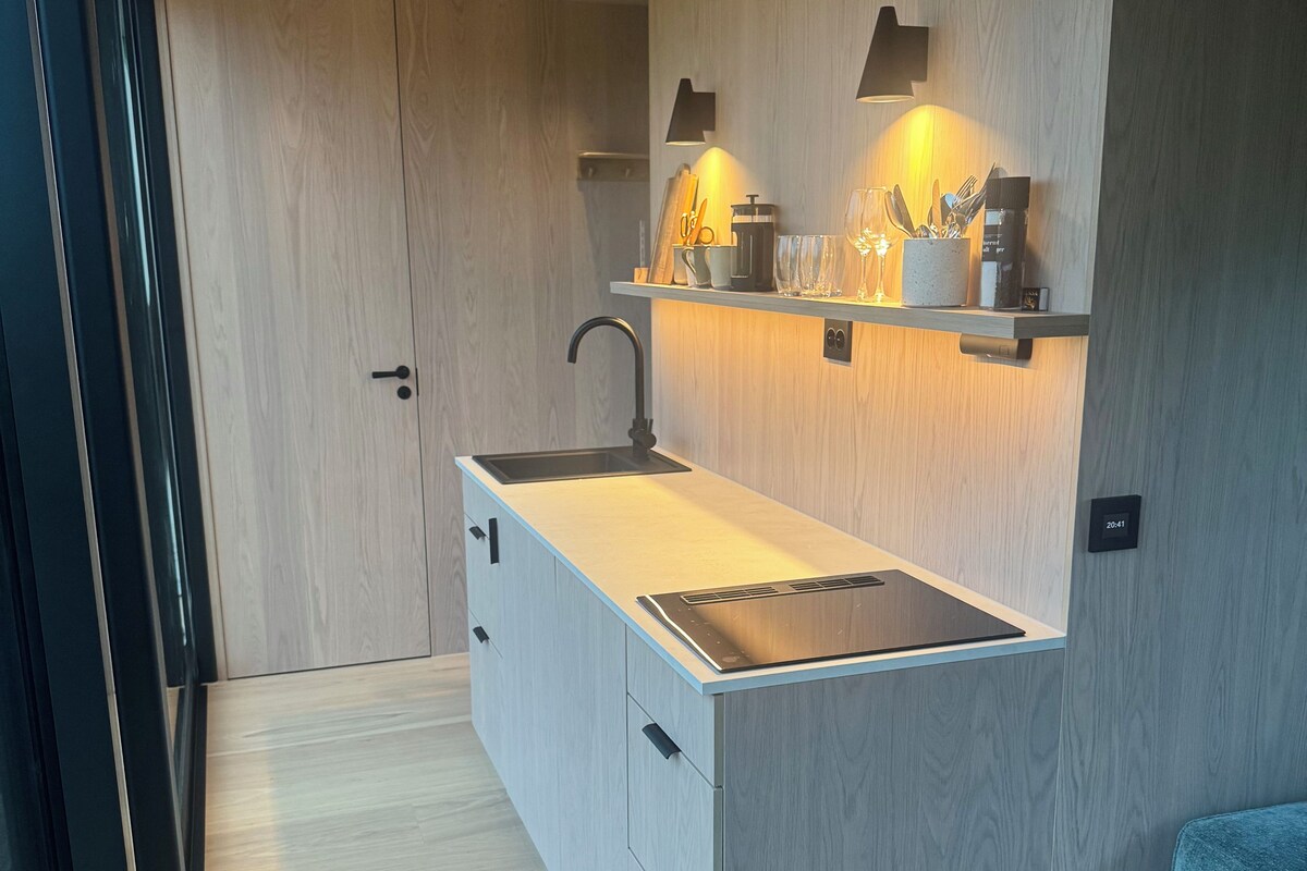 Una cocina moderna con pileta integrada, muebles de madera y encimera.