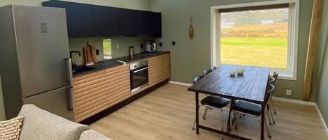 A modern kitchen with skylights, a dining area with a table and chairs, and a sofa.
