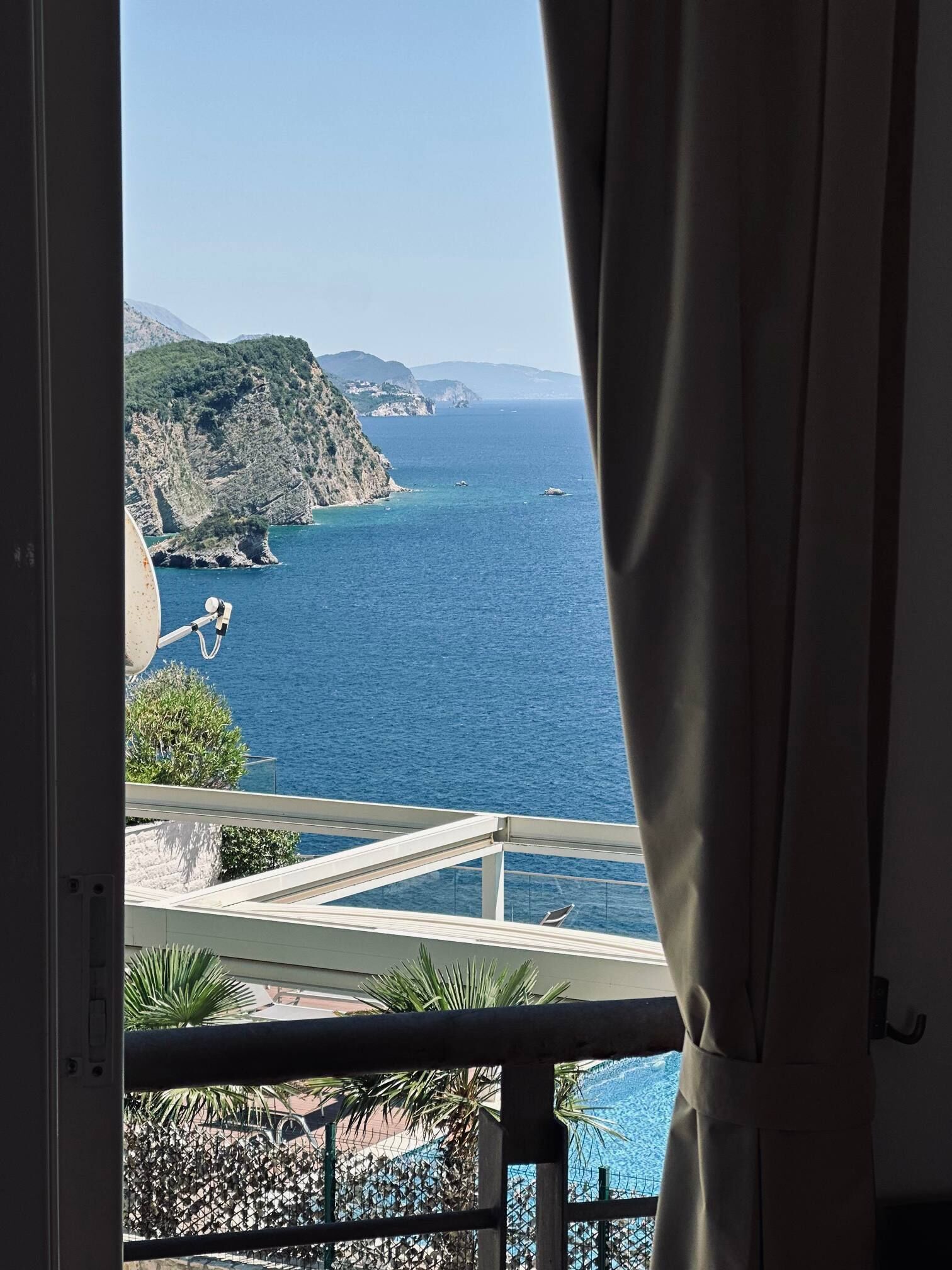 Varanda com vista para o mar e paisagem montanhosa.