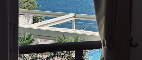 A balcony with a view of the sea and a mountainous landscape.