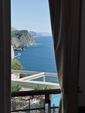 Un balcone con vista sul mare e un paesaggio montuoso.