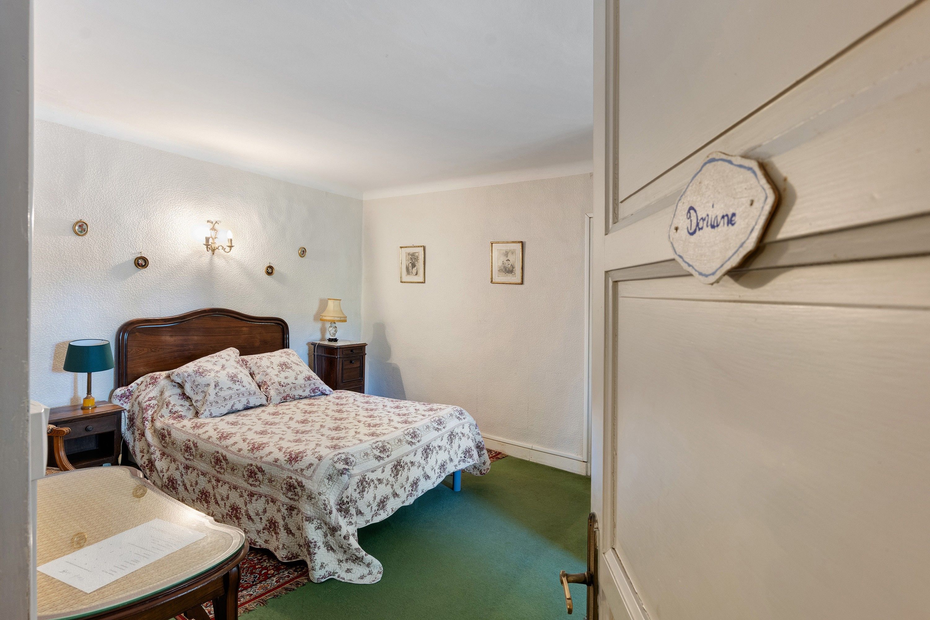 Ein Schlafzimmer mit einem Bett, einem Nachttisch, einer Lampe und einer Kommode.