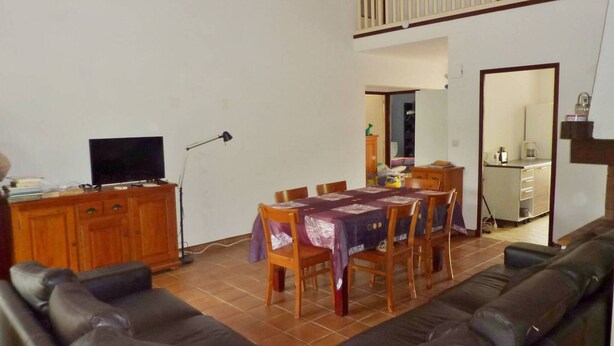 A living room with a sofa, a dining table with chairs, a TV, and a lamp. - Quartier des Goélands, Villa t5 pour 8 N25 (La Grande-Motte)