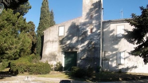 A building with a tall tower, a door, and a small table in the foreground. - Bed and Breakfast 'Chambre Isabeau' with Shared Pool, Shared Garden and Wi-Fi (Carcassonne)