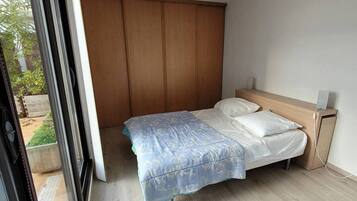 Une chambre à coucher avec un lit, une armoire en bois et une fenêtre.