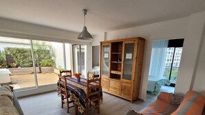 A spacious living area with a dining table, wooden cabinet, and a sofa. - Quartier du port, t4 pour 8 personnes N12 (La Grande-Motte)