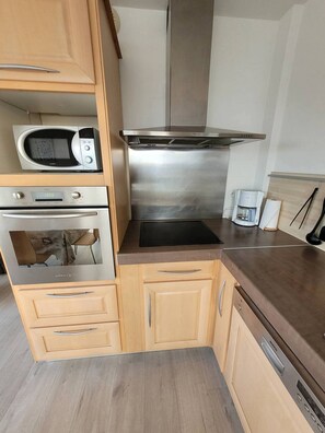 A kitchen with a microwave, oven, and coffee maker.