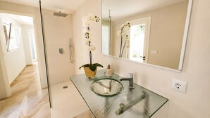 A bathroom with a glass sink, a mirror, and a potted orchid. - Ca na Victòria: Mallorcan Home with Wi-Fi and Air Conditioning (Santa Margalida)