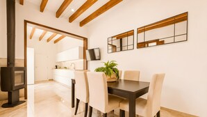 A modern kitchen with white cabinets, a dark wood table, and chairs. - Ca na Victòria: Mallorcan Home with Wi-Fi and Air Conditioning (Santa Margalida)