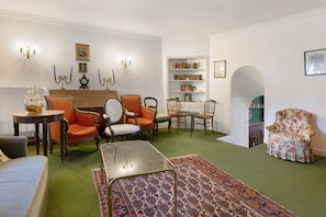 A traditional living room with a fireplace, bookshelves, and classic furniture. - Bed and Breakfast 'Chambre Rolland' with Shared Pool, Shared Garden and Wi-Fi (Carcassonne)