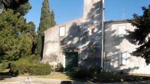 A building with a tall tower, a door, and a small table in the foreground. - Bed and Breakfast 'Chambre Rolland' with Shared Pool, Shared Garden and Wi-Fi (Carcassonne)