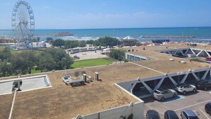 A coastal area with a large Ferris wheel, parking lots, and a clear view of the ocean. - Première ligne Plage, studio pour 2 N20 (La Grande-Motte)