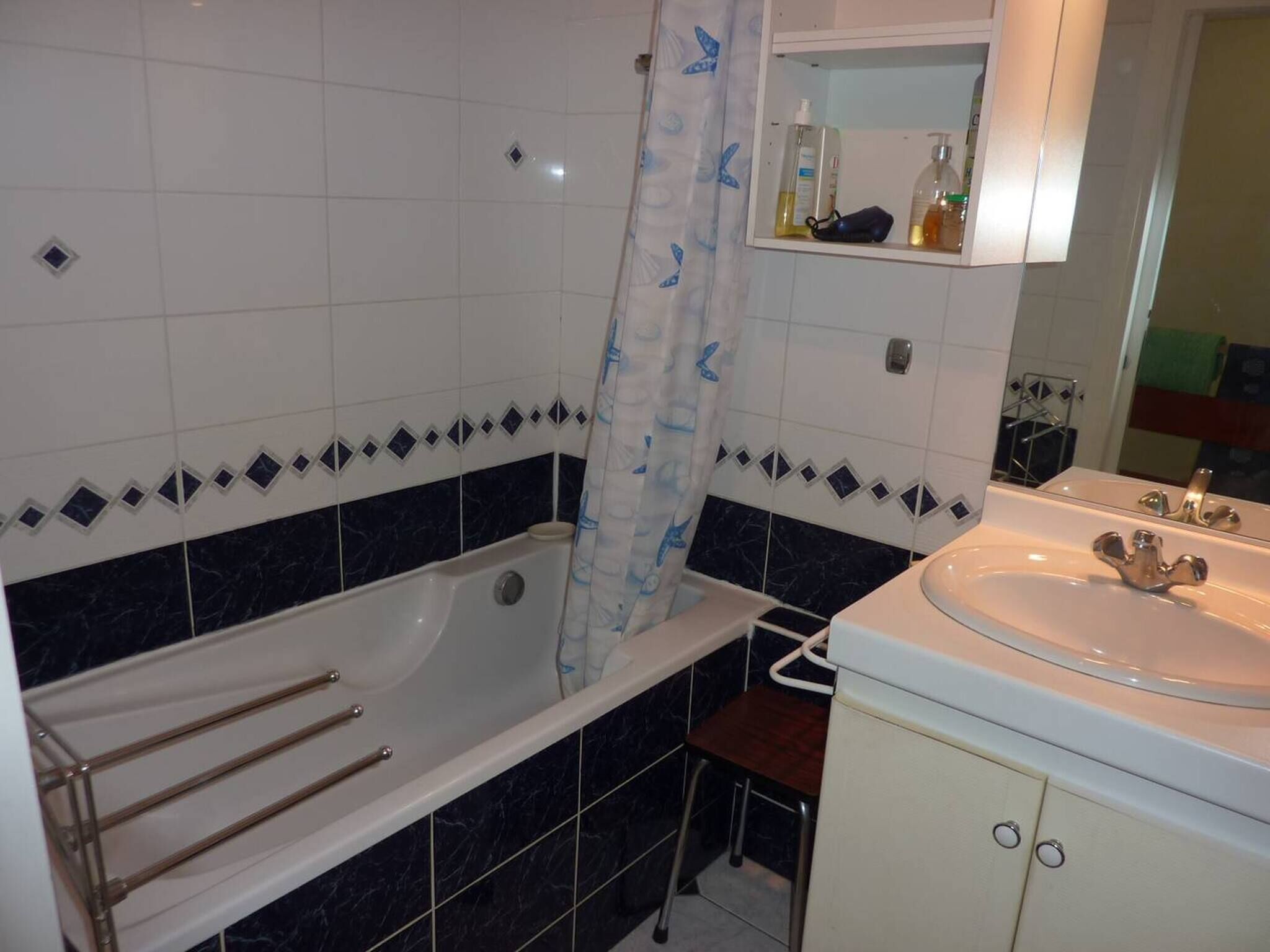A bathroom with a bathtub, a sink, and a mirror.