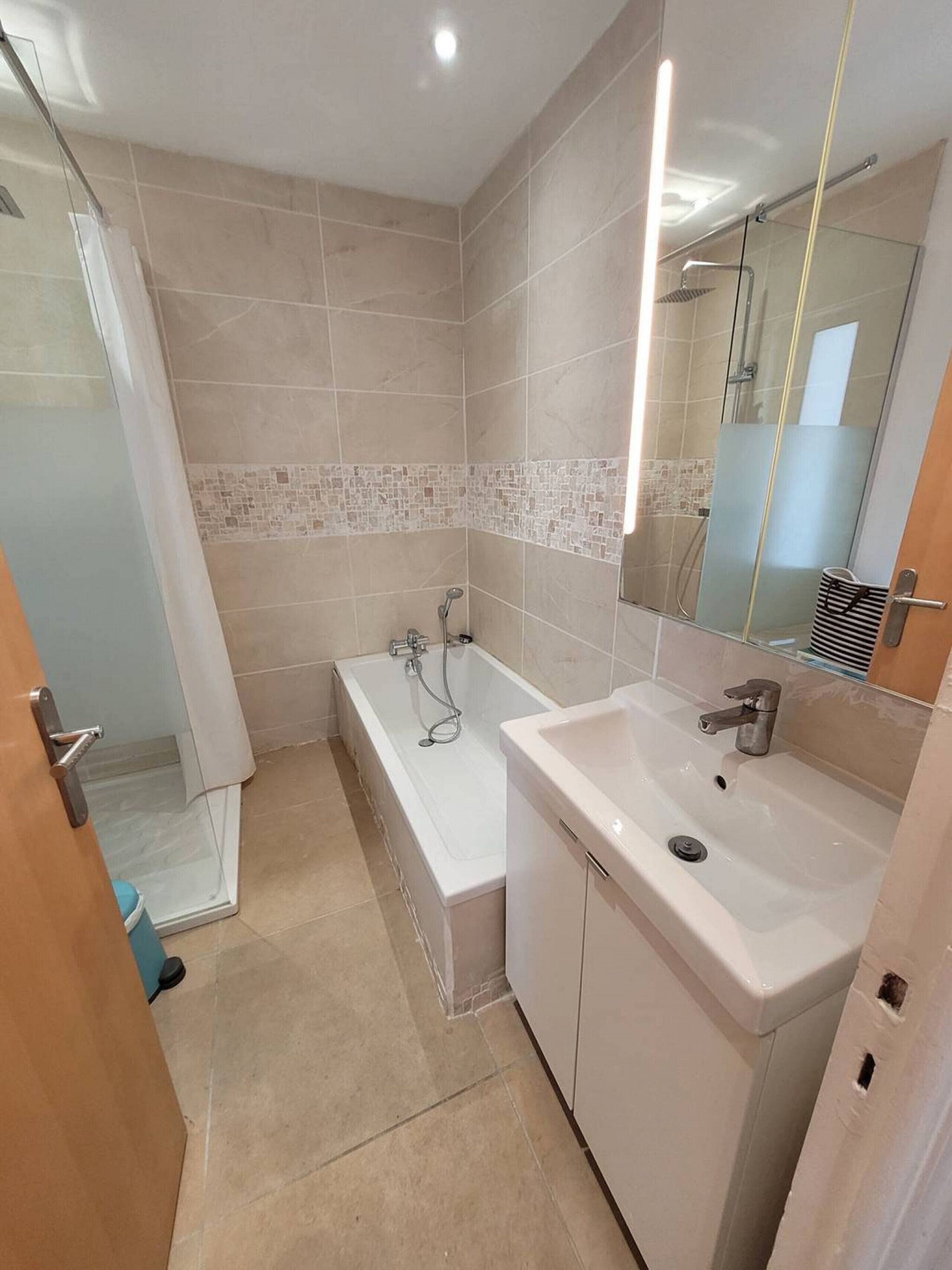Un bagno con vasca, lavandino e zona doccia.