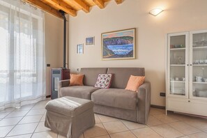 Ein Wohnzimmer mit einer Couch, einem Hocker und einer Vitrine.