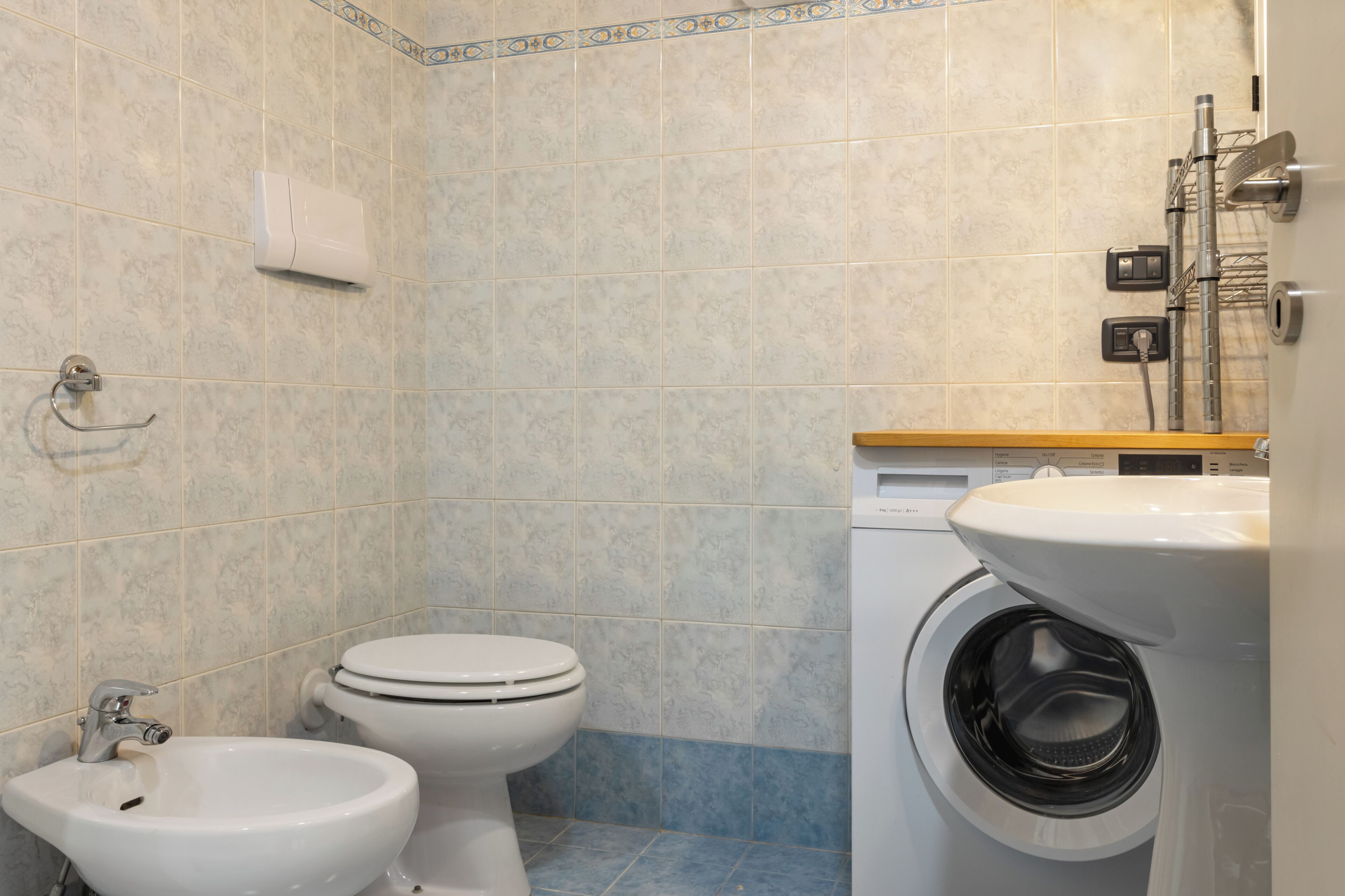 A bathroom with a toilet, bidet, and washing machine.