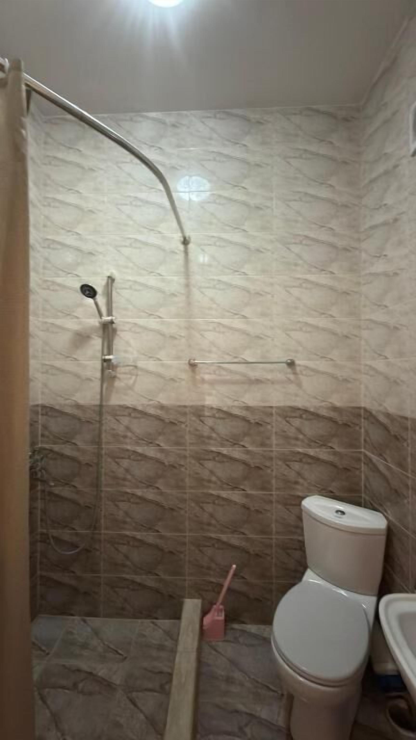 A bathroom with a shower, toilet, and sink.
