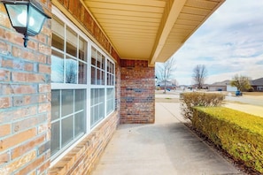 A building with a brick facade, large windows, and a covered entrance area. - The Brick Beauty | Dog-Friendly & Fenced Yard (Bentonville)